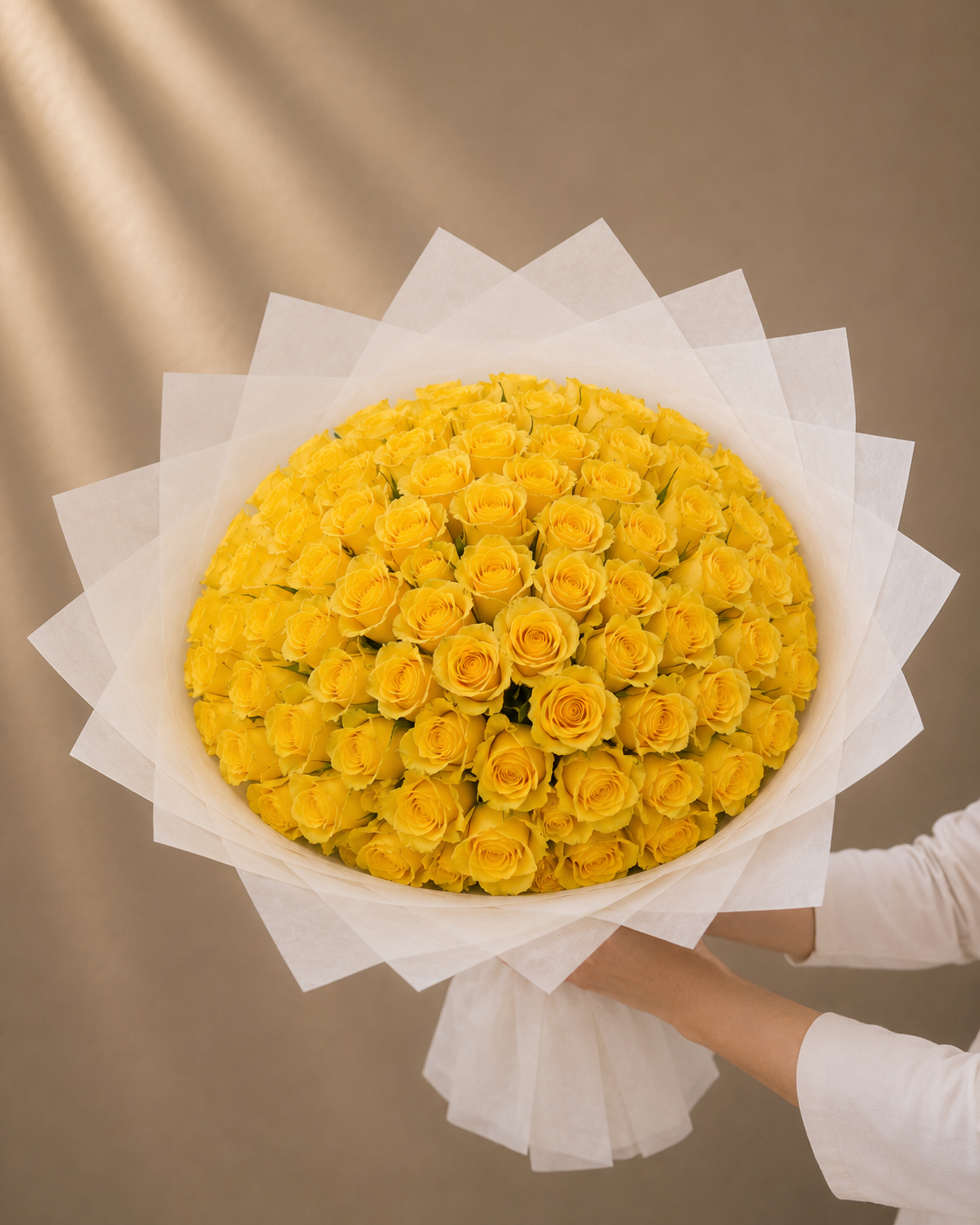 Luxury bouquet of 101 premium fresh yellow roses wrapped in elegant white designer wrapping by Ishbelia Gardens Dubai.