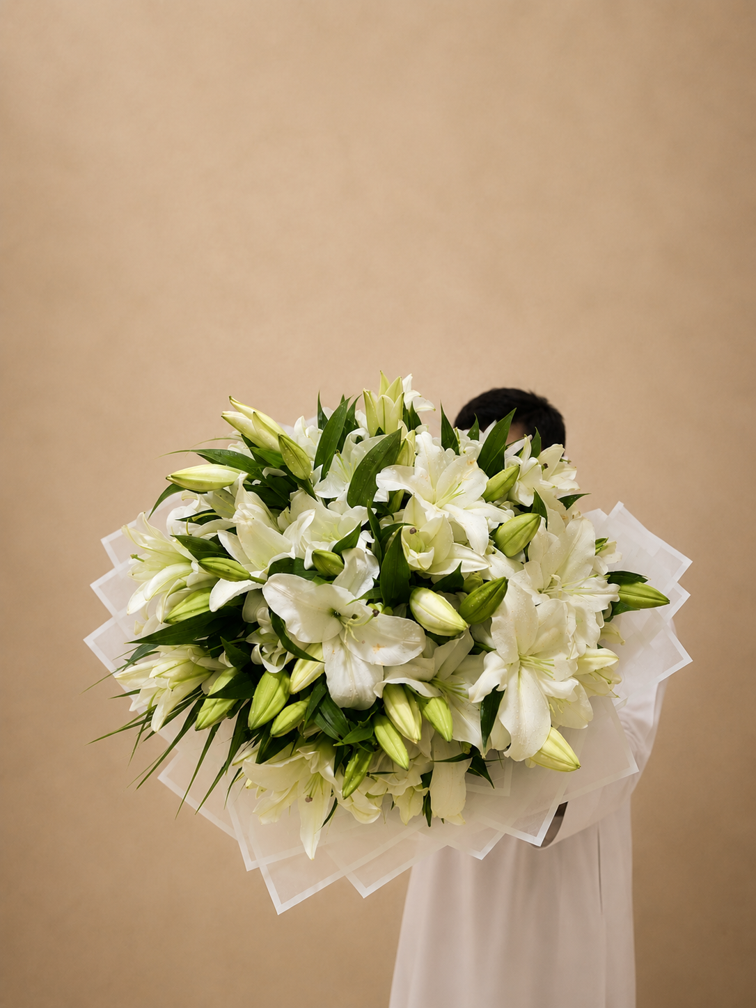 Luxury bouquet of premium white Oriental lilies with fresh lily buds in elegant white wrapping by Ishbelia Gardens Dubai.