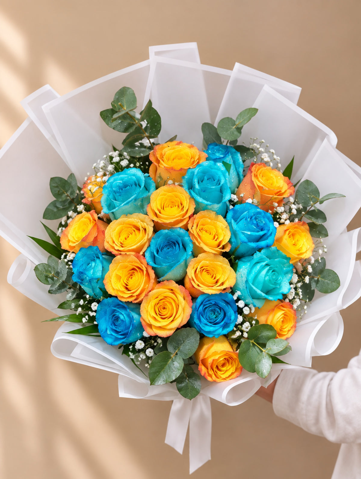 Blue and orange roses bouquet with baby’s breath, eucalyptus and white wrapping in Dubai