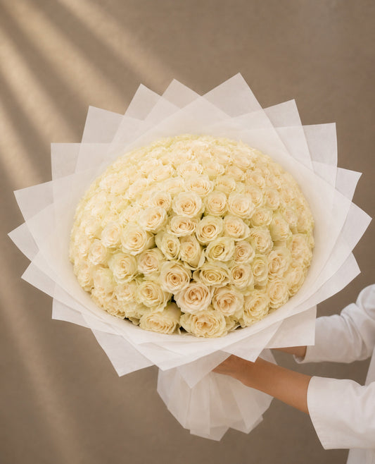 Luxury bouquet of 101 premium fresh white roses wrapped in elegant white designer wrapping by Ishbelia Gardens Dubai.